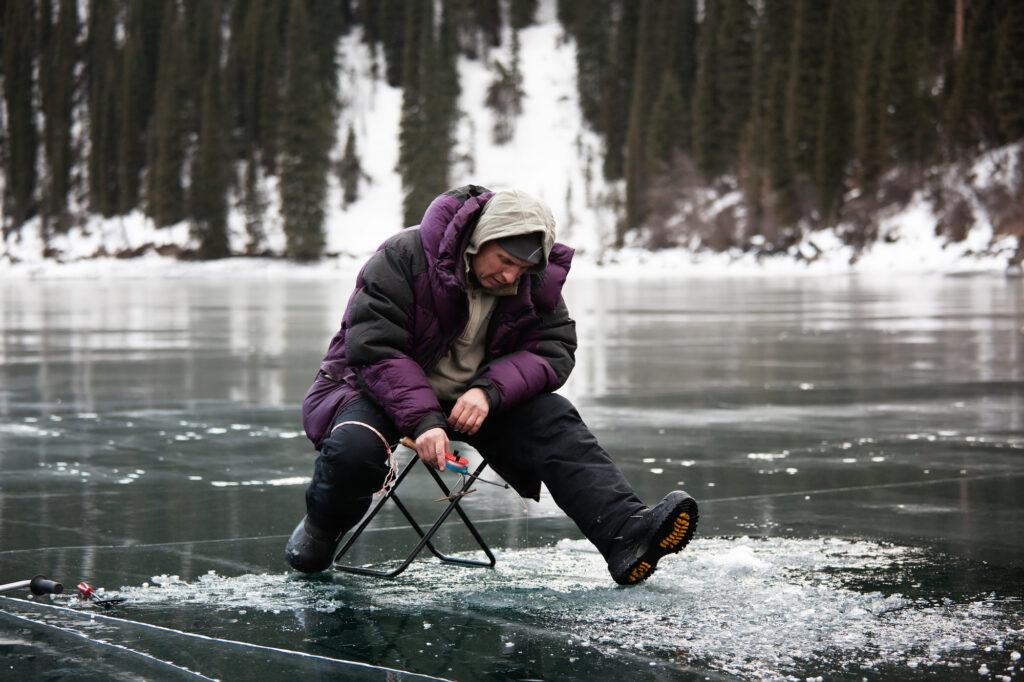 Ice fisherman on clear ice.