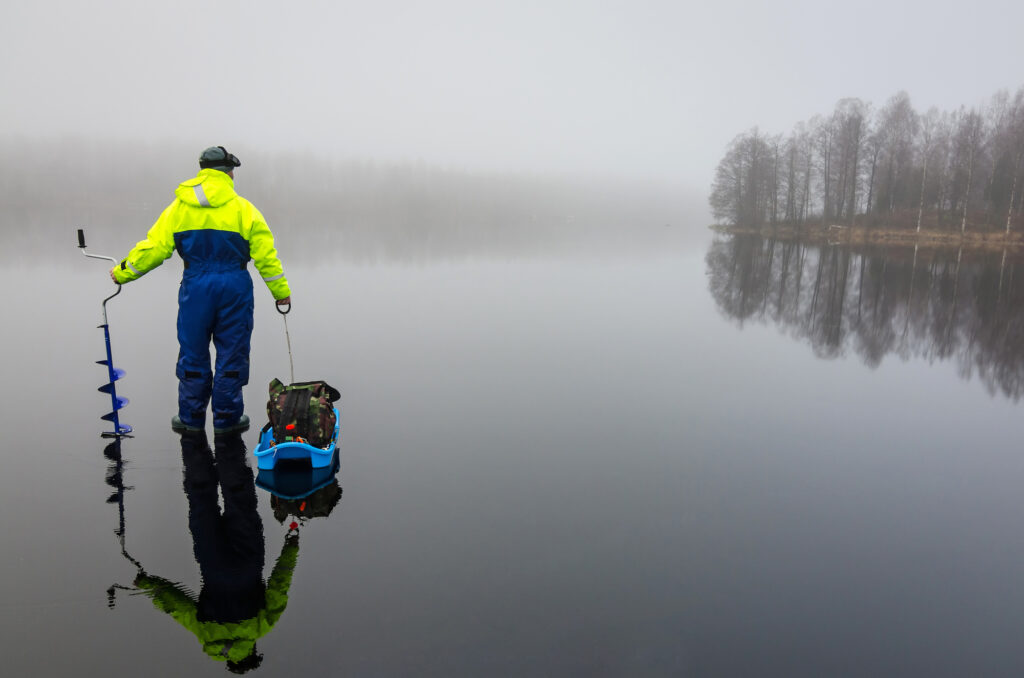 Ice fisherman on gray ice