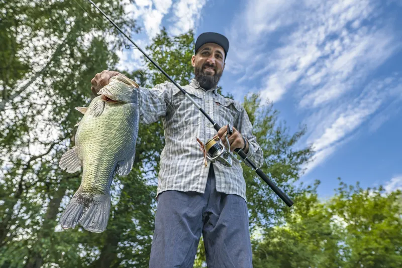 Pleased Angler Holds Big Bass Caught With Spinning Rod